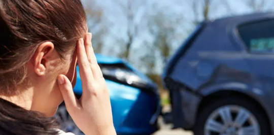 woman hand on head looking at rear end accident